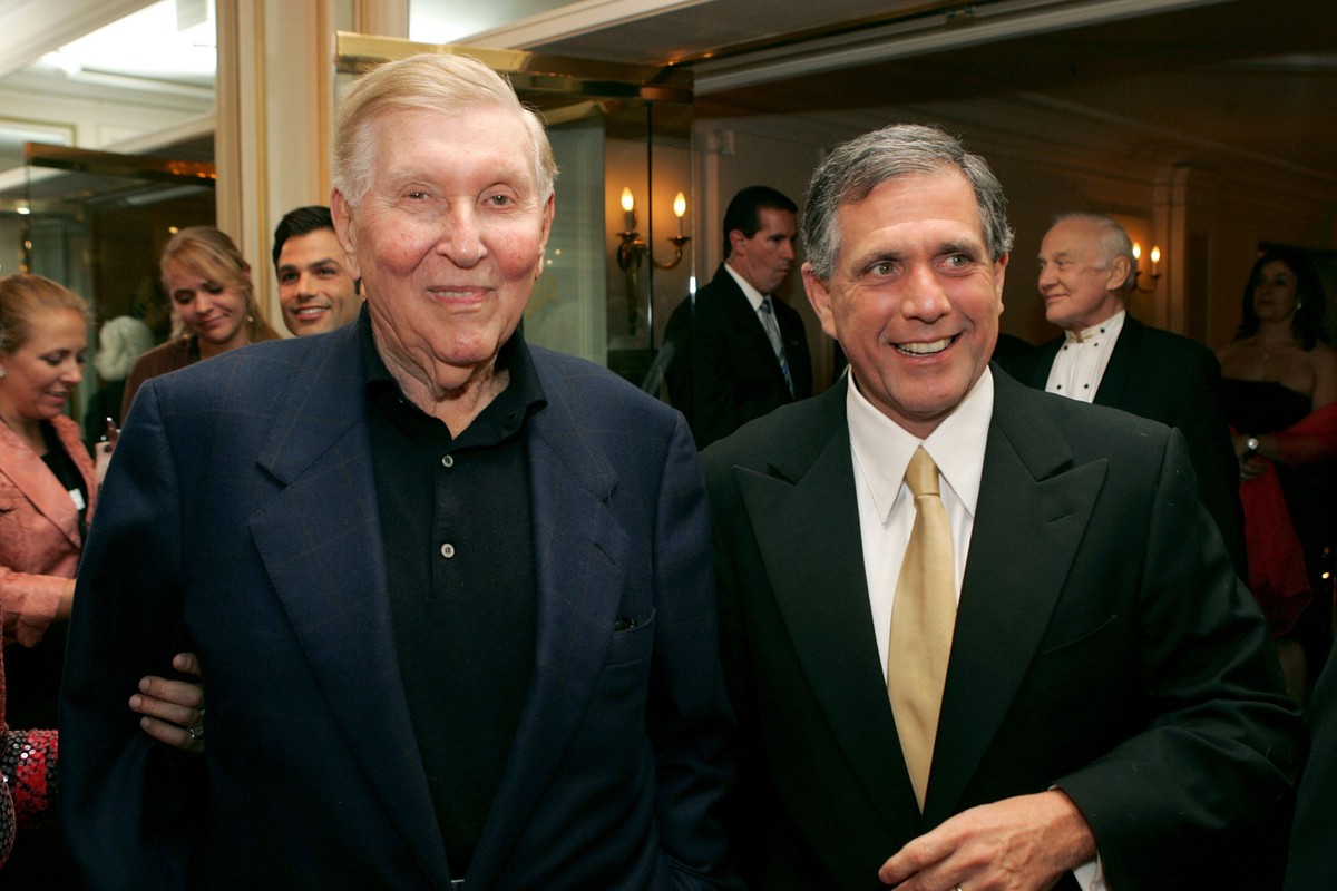 Two old men in suits pose and smile for a picture.